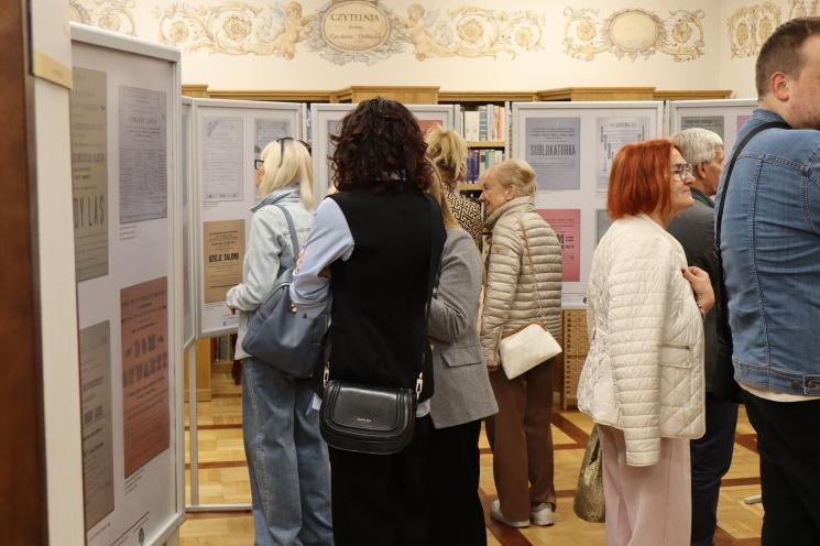 grupa ludzi siedzi, 2 osoby stoją