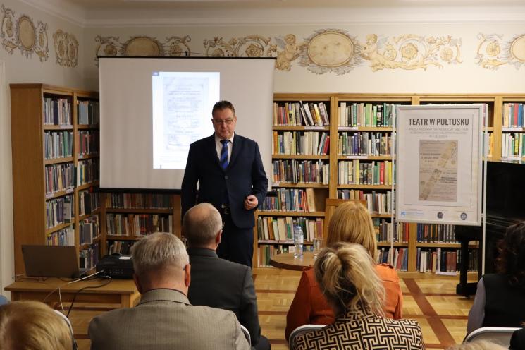 grupa ludzi siedzi, 2 osoby stoją