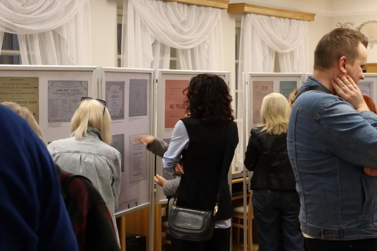 grupa ludzi siedzi, 2 osoby stoją