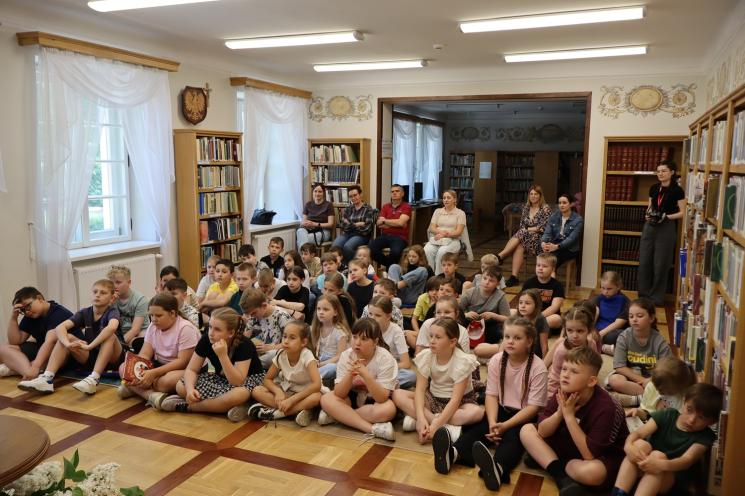 kolorowe zdjęcie, 3 osoby, 2 kobiety i 1 mężczyzna, pozują do zdjęcia na tle książek 