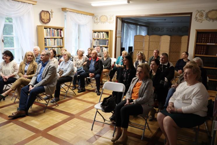 7 osób, 5 siedzi, 2 osoby przemawiają