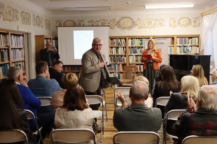 grupa ludzi siedzi, 2 osoby stoją