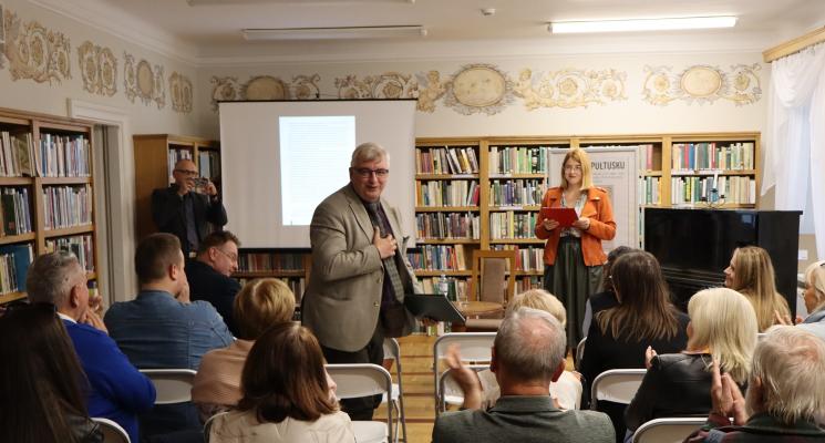 grupa ludzi siedzi, 2 osoby stoją