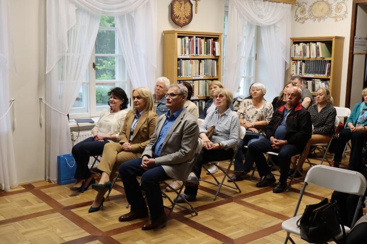 7 osób, 5 siedzi, 2 osoby przemawiają