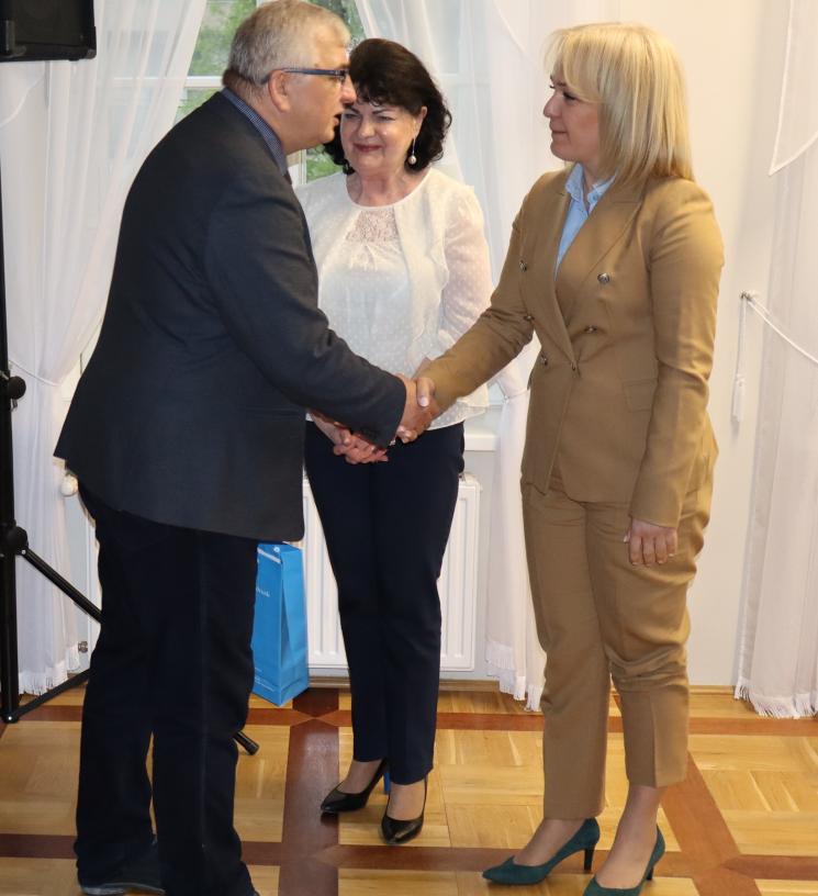 7 osób, 5 siedzi, 2 osoby przemawiają