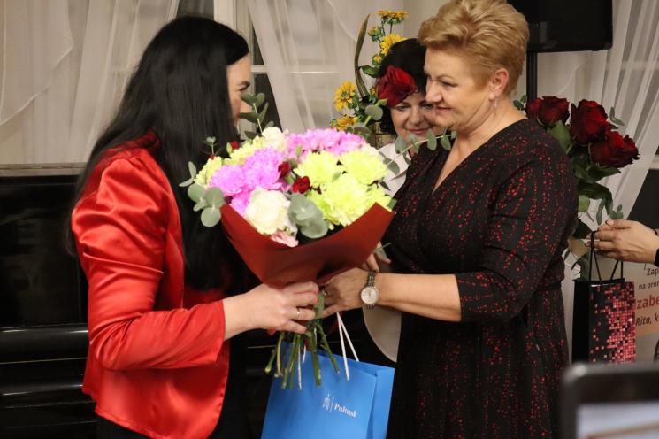 kolorowe zdjęcie, grupa ludzi siedzi na krzesłach, zdjęcie na tle książek