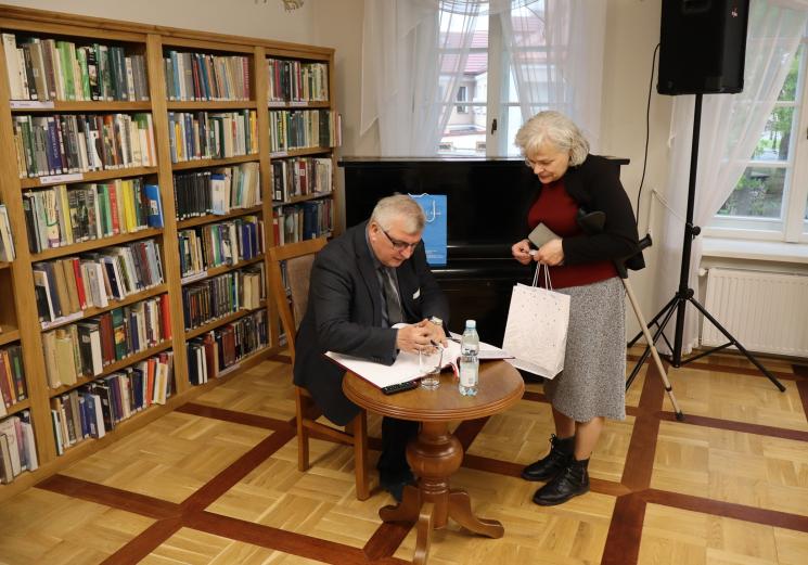 7 osób, 5 siedzi, 2 osoby przemawiają