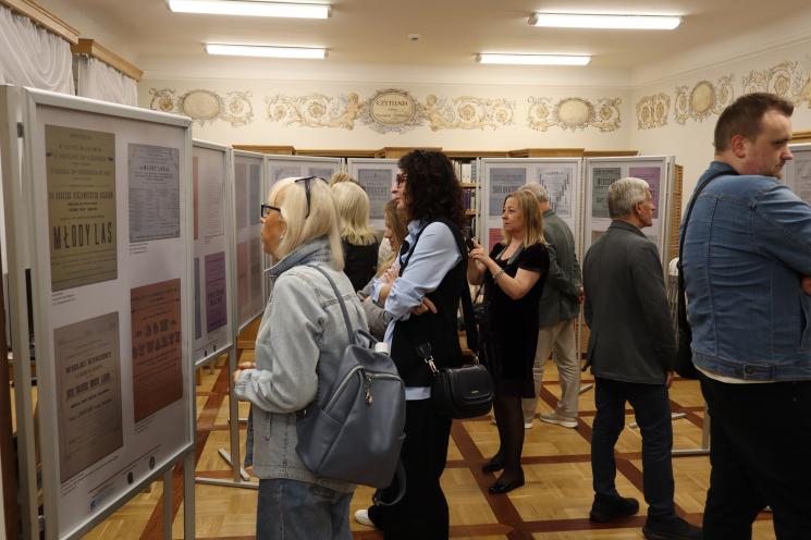grupa ludzi siedzi, 2 osoby stoją