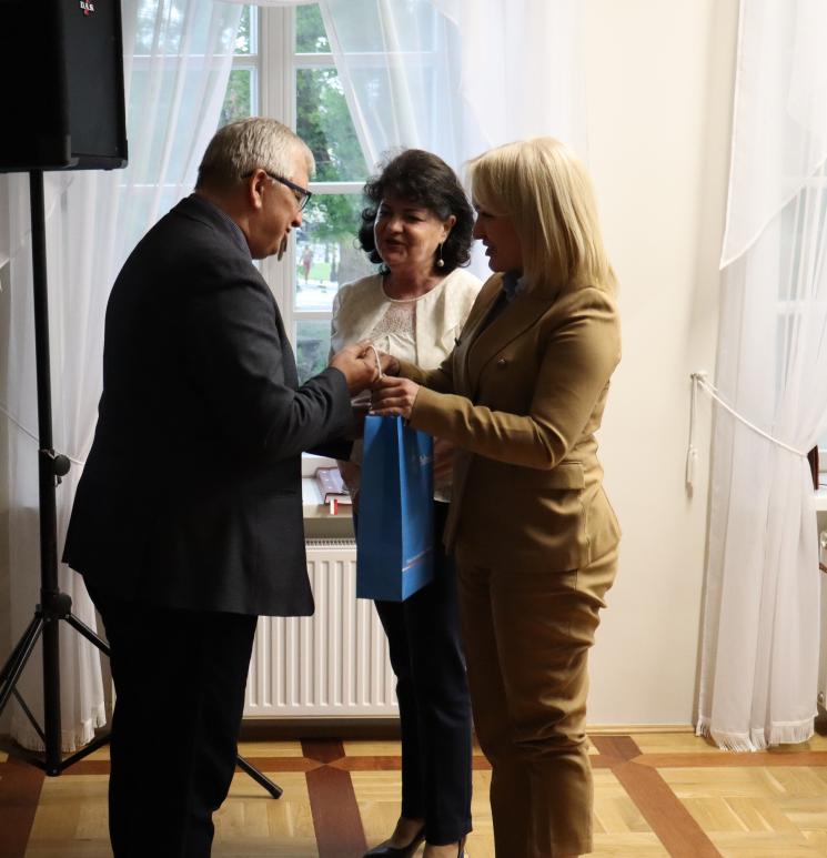 7 osób, 5 siedzi, 2 osoby przemawiają