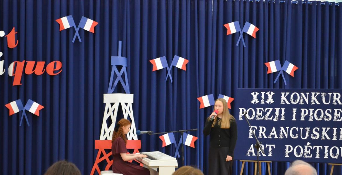 3 osoby siedza jesdna stoi i spiewa