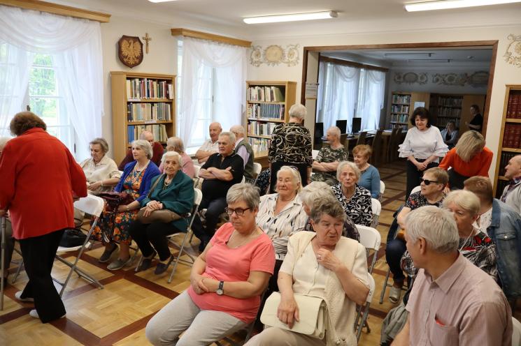 kolorowe zdjęcie, 6 osób, 5 siedzi, 1 stoi i przeprowadza prezentację