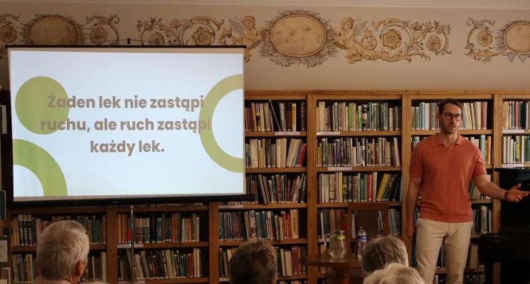 kolorowe zdjęcie, 6 osób, 5 siedzi, 1 stoi i przeprowadza prezentację